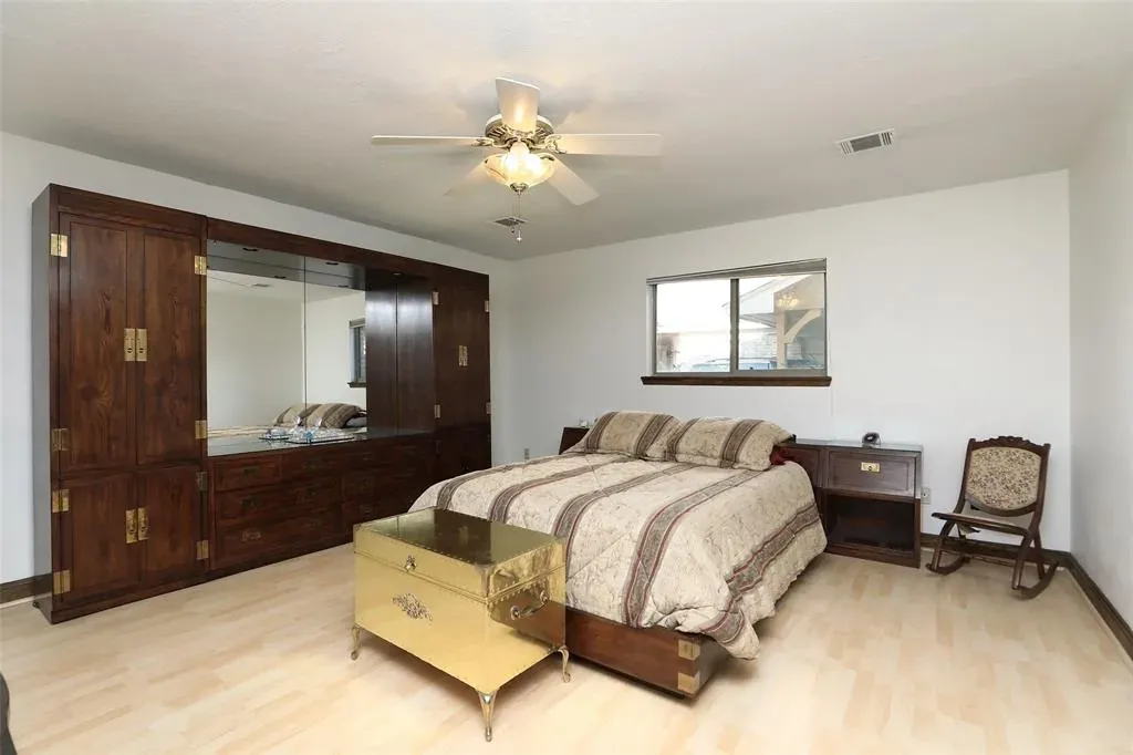 Before: Whole home remodel in Hyde Park, Austin, TX with a dark wood armoire and a ceiling fan